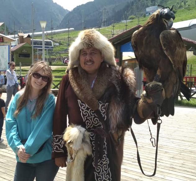 Kathleen Connell'20 stands with a Kazahk eagle hunter near Almaty, Kazakhstan