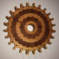 A wooden gear made of interlocking circular pieces of wood of various colors.