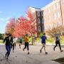 The women’s Track and Field team runs behind Wood Hall in autumn.