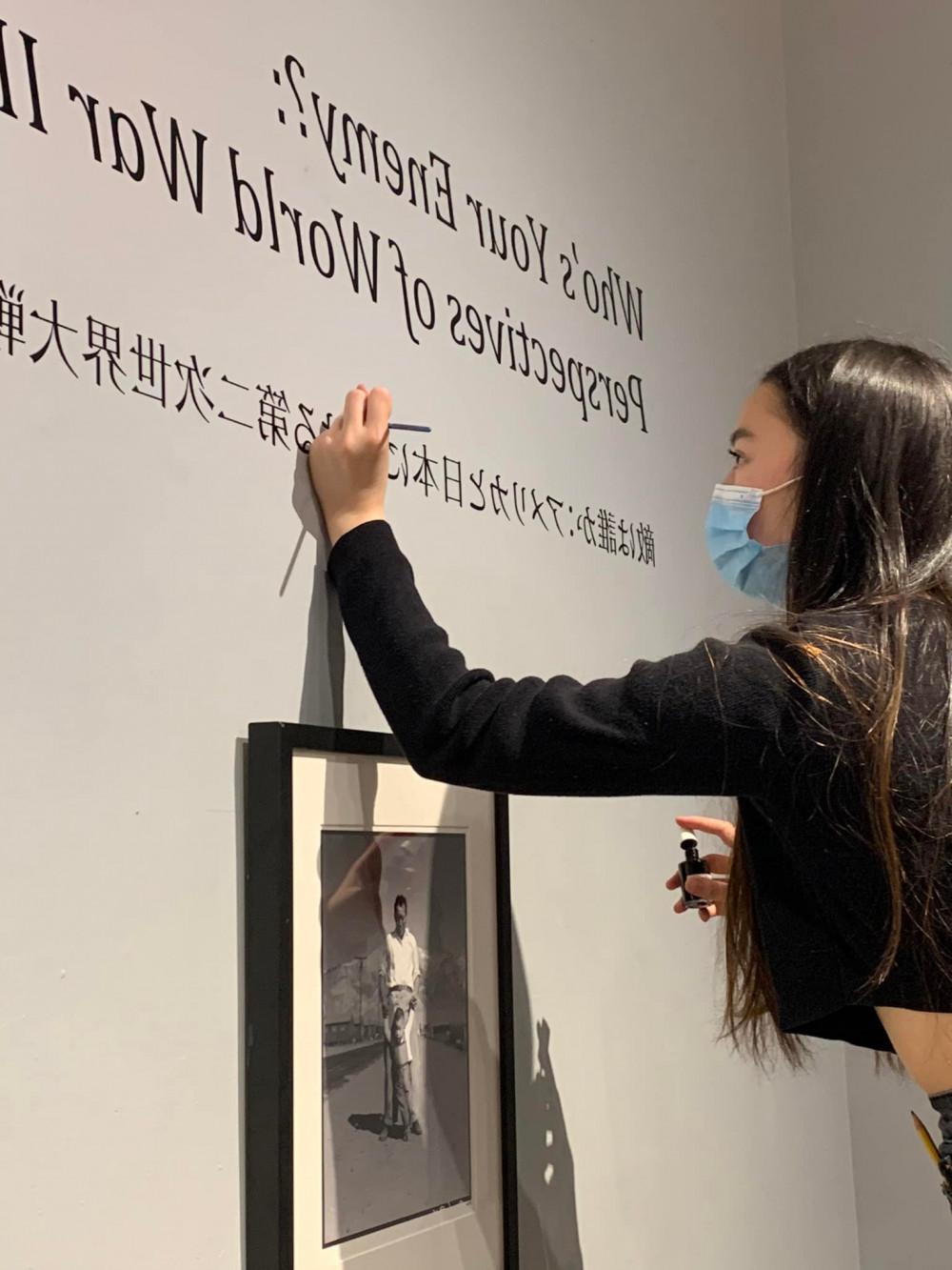 Midori Tanada '23 touches up the vinyl for the exhibit done by students in Susan Furukawa's Narratives of War and Peace Japanes...