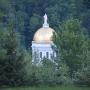 The Vermont state house hidden behind some trees.